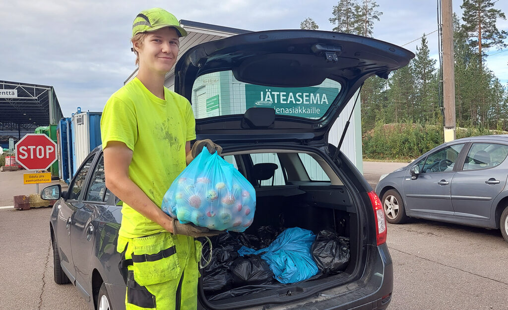 Kuvassa on Juho Reunala avustamassa asiakasta lajittelussa jäteasemalla.